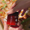 Hand putting FODZYME onto pizza