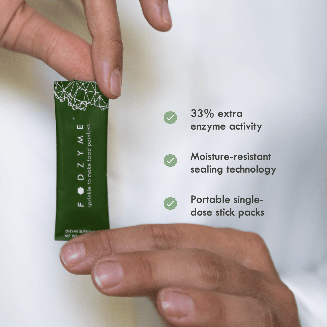 Hands holding a FODZYME single-serve stick pack. Text highlights three features: 33% extra enzyme activity, moisture-resistant sealing technology, and portable single-dose stick packs.